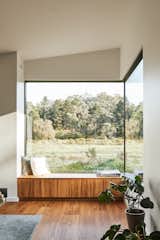 The house's largest expanse of glass comes at this living-room corner, which a window seat helps make a destination, be it for Zara working with her laptop of the couple's guests.