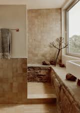 For a bathroom in the new addition, the architects utilized the former addition's rocky foundation, complemented by zellige tile.