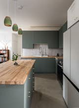 The kitchen, which friends helped put together, pairs affordable Ikea cabinetry with birch countertops and glazed brick tile.