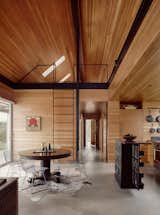 The combined kitchen and dining room, featuring two pieces of family-heirloom furniture, feel spacious thanks to a vaulted ceiling; it and the walls are clad in Douglas fir.