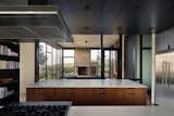 Off the kitchen is a screened porch that, with the help of an operable sliding door (seen here extending nearly halfway across) that can close itself off from the rest of the otherwise air-conditioned house.