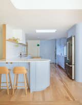 Architect Allison Bryan and her firm, Open Studio Collective, took inspiration from a curved bathroom vanity to create a curved counter extension in the kitchen.