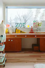 Wanting to preserve the original stained-plywood cladding in daughter Zoe's room while brightening the space, the couple and architect Allison Bryan chose a middle ground: replacing the floors and ceiling while retaining the plywood built-in desk and closet doors.