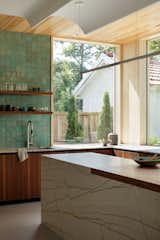 Marble was used on the kitchen island, complimented by walnut cabinetry and butcher-block countertop, as well as a backsplash of ceramic tile.