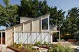 A new detached garage is topped with a guest room, overlooking the meadow and pool.
