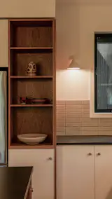 The Ikea cabinet doors have pulls by Schoolhouse, and are paired with custom shelving by Al Stone. The backsplash tile is Zenia Solar Fielde Matte by Bedrosians. The pottery is by the Los Angeles studio Kat and Roger.