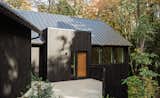 The house is clad with shou sugi ban-treated cedar siding.
