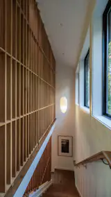 The custom wood screens bring privacy while still allowing the window light to spread. The stairway leads to downstairs bedrooms. The Akari 23A Pendant is by Noguchi. The artwork is by Jon Gottshall.
