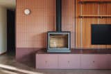 A centerpiece of the living room is the Stuv 16-Cube fireplace, sitting atop Ikea drawers outfitted with iKustom metal fronts. The tiles behind the stove are by Micro, and the wall sconce by Viscosi.