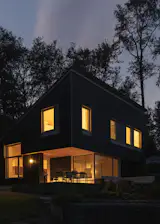 The house cantilevers over the east-facing corner to create covered outdoor space, near the black Sarek table and chairs by Article.