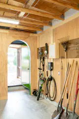 Plywood paneling lines the garage's interior, including an arched doorway. To add a small artful detail, the couple saved the wood cutout from the top of the arch and mounted it above, inverted.