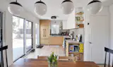 The kitchen as seen from the dining table, with the home's new sliding-glass doors. On the upper shelves is a George Nelson Tripod Desk Clock ($725)