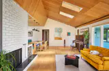 The living room includes Chris's family's piano, which was built in the 1920s. New oak flooring brings improved reverberation and acoustics when his musician friends play it. The sofa at right belonged to Chris's parents and was recovered.