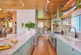 The new kitchen includes Corian Quartz countertops, as well as new lower cabinetry from Reform and glazed Fireclay tile on the right wall, comlementing the fireplace's white brick.