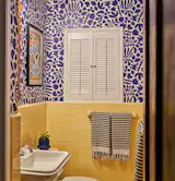 New wallpaper inspired by artist Henri Matisse's cut-paper artwork helps (in tandem with the original yellow tile) give the bathroom a pop of color.