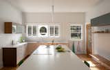 Kitchen, Dark Hardwood Floor, Dishwasher, Drop In Sink, Colorful Cabinet, Ceiling Lighting, White Cabinet, Wood Cabinet, Engineered Quartz Counter, Medium Hardwood Floor, and Pendant Lighting  Photo 11 of 19 in Dundee House by Traction Architecture