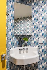 The powder room gets its geometric edge from Heath Ceramics for Hygge and West wallpaper.