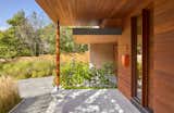 As an acknowledgement of the clients’ desire for mid-century Prairie Style architecture, the design incorporates a language of low-slung, horizontal planes and deep overhangs. The entry and soffits are detailed with Brazilian massaranduba boards, complementing the mahogany windows and front door.