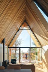 A contemporary interpretation of the traditional A-frame shape, the lofted ceiling is delineated with Western red cedar boards. The living area features stunning views of the lake below through a triple-glazed opening.