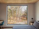 Located at the rear for a more peaceful environment, the bedroom offers immersive views of the forest through a large picture window.