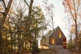 The Bunkie’s split roof design generates distinct elevations on each side of the structure – a tall, glazed facade faces the lake, and a wider, more opaque façade faces the forest.