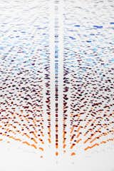 The seemingly floating discs are anchored by tiny teardrop-shaped plumb bobs, their weight creating layers upon layers of overlapping straight lines.