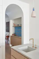Hand-cast whimsical Spanish tiles line a bar alcove carved into the extruded archway that connects the dining room to the kitchen, a nod to the clients’ passion for craft. The owner’s ceramics are displayed above the bar.