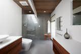 Klopf Architecture and Jesse Ososki Art remodeled an existing Eichler atrium home into a brighter, more open, and more functional version of its original self. 

The goals were to preserve the Eichler look and feel without the need to strictly adhere to it. The scope of work included re-configuring the master bedroom/bath, the kitchen, and the hall bath/laundry area, as well as updating interior finishes throughout to be more sophisticated.

The owners are detail-oriented and were very involved in the design process, down to the selection of lighting controls and stainless steel faceplates.Their design aesthetic leans toward the Scandinavian — light and bright, with simple straight lines and pure geometric shapes.

The finish flooring is large porcelain tile (24” x 24”) in a neutral grey tone, providing a uniform backdrop against which other materials can stand out. The same tile continues into the shower floor (with a different finish texture for slip-resistance) and up the shower/tub walls (in a smaller size). Heath Classic Field ceramic tile in Modern Blue was used sparingly, to add color at the hall bath vanity backsplash and at the shampoo niches in both bathrooms. Back-painted soda glass in pale blue to match the Heath tile was used at the kitchen backsplash. This same accent color was also used at the front entry atrium door. Kitchen cabinetry, countertops, appliances, and light fixtures are all white, making the kitchen feel more airy and light. Countertops are Caesarstone Blizzard.

The owners chose to keep some of the original Eichler elements:  the concrete masonry fireplace; the stained tongue-and-groove redwood ceiling decking; and the luan wall paneling. The luan paneling was lightly sanded, cleaned, and re-stained. The owners also kept an added element that was installed by a previous owner: sliding shoji panels at all bedroom windows and sliding glass doors, for both privacy and sun control. Grooves were cut into the new tile flooring for the shoji panels to slide in, creating a more integrated look. Walnut was used to add warmth and contrast at the kitchen bar top and niche, the bathroom vanities, and the window sill/ledge under the kitchen window.

This Burlingame Eichler Remodel is a 2,121 sf, 4 bedroom/2 bath home located in the heart of Silicon Valley.

Klopf Architecture Project Team: John Klopf, Klara Kevane and Yegvenia Torres Zavala
Contractor: Jesse Ososki Art 
Structural Engineer: Emmanuel Pun
Photography ©2018 Mariko Reed
Location: Burlingame, CA
Year completed: 2017



