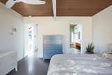 Klopf Architecture and Jesse Ososki Art remodeled an existing Eichler atrium home into a brighter, more open, and more functional version of its original self. 

The goals were to preserve the Eichler look and feel without the need to strictly adhere to it. The scope of work included re-configuring the master bedroom/bath, the kitchen, and the hall bath/laundry area, as well as updating interior finishes throughout to be more sophisticated.

The owners are detail-oriented and were very involved in the design process, down to the selection of lighting controls and stainless steel faceplates.Their design aesthetic leans toward the Scandinavian — light and bright, with simple straight lines and pure geometric shapes.

The finish flooring is large porcelain tile (24” x 24”) in a neutral grey tone, providing a uniform backdrop against which other materials can stand out. The same tile continues into the shower floor (with a different finish texture for slip-resistance) and up the shower/tub walls (in a smaller size). Heath Classic Field ceramic tile in Modern Blue was used sparingly, to add color at the hall bath vanity backsplash and at the shampoo niches in both bathrooms. Back-painted soda glass in pale blue to match the Heath tile was used at the kitchen backsplash. This same accent color was also used at the front entry atrium door. Kitchen cabinetry, countertops, appliances, and light fixtures are all white, making the kitchen feel more airy and light. Countertops are Caesarstone Blizzard.

The owners chose to keep some of the original Eichler elements:  the concrete masonry fireplace; the stained tongue-and-groove redwood ceiling decking; and the luan wall paneling. The luan paneling was lightly sanded, cleaned, and re-stained. The owners also kept an added element that was installed by a previous owner: sliding shoji panels at all bedroom windows and sliding glass doors, for both privacy and sun control. Grooves were cut into the new tile flooring for the shoji panels to slide in, creating a more integrated look. Walnut was used to add warmth and contrast at the kitchen bar top and niche, the bathroom vanities, and the window sill/ledge under the kitchen window.

This Burlingame Eichler Remodel is a 2,121 sf, 4 bedroom/2 bath home located in the heart of Silicon Valley.

Klopf Architecture Project Team: John Klopf, Klara Kevane and Yegvenia Torres Zavala
Contractor: Jesse Ososki Art 
Structural Engineer: Emmanuel Pun
Photography ©2018 Mariko Reed
Location: Burlingame, CA
Year completed: 2017




