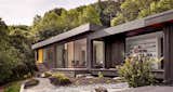 The dark-stained cedar siding is at home on the wooded site.  Bright interiors are airy inside.