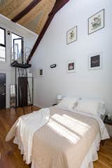 Bedroom, Bed, Wardrobe, Night Stands, Table Lighting, and Medium Hardwood Floor  Photo 9 of 14 in Rent One of These Stunning Lofts in a Converted Brooklyn Church from St Marks from @nooklyn