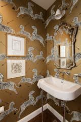 In a  complete remodel/addition of a 1920's Monterey Colonial on one of Sacramento's greatest streets, the powder room comes alive with wallpaper depicting galavanting zebras for a playful touch. Photo by Kat Alves