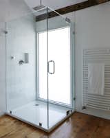 A window wall of privacy glass illuminates the shower stall, which features a 16” square stainless steel shower head.  Photo 6 of 14 in twist farmhouse by Tom Givone