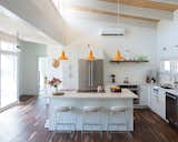 Kitchen, Medium Hardwood Floor, Refrigerator, Pendant Lighting, White Cabinet, Range, Cooktops, and Drop In Sink Leo counter stools  Photo 14 of 34 in light fixtures by Russell Rolffs from Favorites