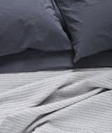 AREA Inc. THEO blue. Soft, mid-weight, 100% cotton blankets and throws. The mix of colors, small chain-link pattern and knitted texture makes for a unique and functional blanket bringing comfort to you and your home.