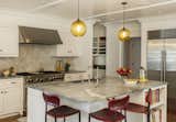 Niche Solitaire pendants in Amber glass add a classic touch to this New England kitchen. 