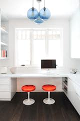 In this home office, a trio of Solitaire Pendants in Sapphire Glass hangs in the center of the room, adding a pop of color to the otherwise clean, neutral palette. "We chose the Niche Sapphire pendant lights for a fresh pop of color and to coordinate with the custom high gloss subtle blue millwork," Hungerford shares. The hint of orange accents also adds another fresh layer to this office while complementing the handmade blue pendant lights.  