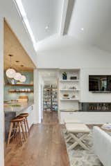 A trio of Solitaire pendants in Opaline glass hangs above the kitchen island. The milky color of our opaque glass emits a soft glow, which is further diffused by frosted bulbs. This white hue complements the clean, minimalist interior while turquoise and yellow accents add a subtle pop of color. With stylish, sleek appliances, open layouts, and Niche glass pendant lights, an elegant display becomes the center of attention in this modern kitchen. 