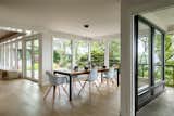 Dining Room, Bench, Pendant Lighting, Chair, Light Hardwood Floor, and Table Wall of windows and dining room, views out to Lake Washington  Photo 6 of 14 in Windermere Midcentury Renovation +ADU by CAST architecture