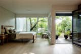 Bedroom, Bed, Night Stands, Bench, and Light Hardwood Floor Primary suite, curved midcentury brick wall, garden  Photo 10 of 14 in Windermere Midcentury Renovation +ADU by CAST architecture