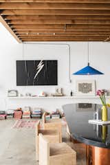 For the dining area, Breer custom-designed a table with a brass base and a marble top. A set of minimalist wood chairs and a bright blue pendant made by Simon LeComte, owner of Amsterdam Modern, complete the tableau.