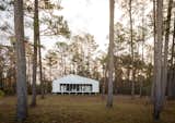 The metal-clad tiny house that architect Will Randolph of Archimania designed for his uncle and aunt, Jon and Niki Nash, stands in a natural clearing surrounded by pine, oak, and hickory trees in Okitebbeha County, Mississippi.