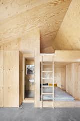 Lookofsky outfitted the bedroom with built-in pine plywood bunkbeds, walls, and a ceiling. The bathroom and a closet are also wrapped in plywood.