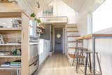 Sunlight bounces off white-painted shiplap walls in the kitchen and the sleeping loft; the flooring is from Pergo.