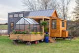 An attached greenhouse ties the cedar-and-metal tiny house to nature.
