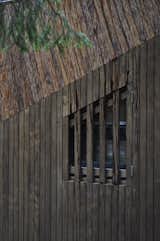 The vertical pine siding on the exterior references the texture and form of tree trunks in the woods.