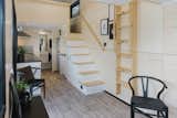 A storage-filled staircase leads to one of the loft-style bedrooms, while a wood ladder accesses the second loft-style bedroom.