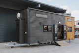 Dark gray vinyl siding wraps around the exterior of the Kingfisher tiny home.