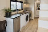 The sunlight-filled kitchen, which is adjacent to the bathroom, is outfitted with a dishwasher and laminate counters.