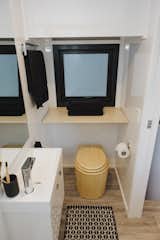 The bathroom features a folding shelf that can stores towels or clean clothes while showering.